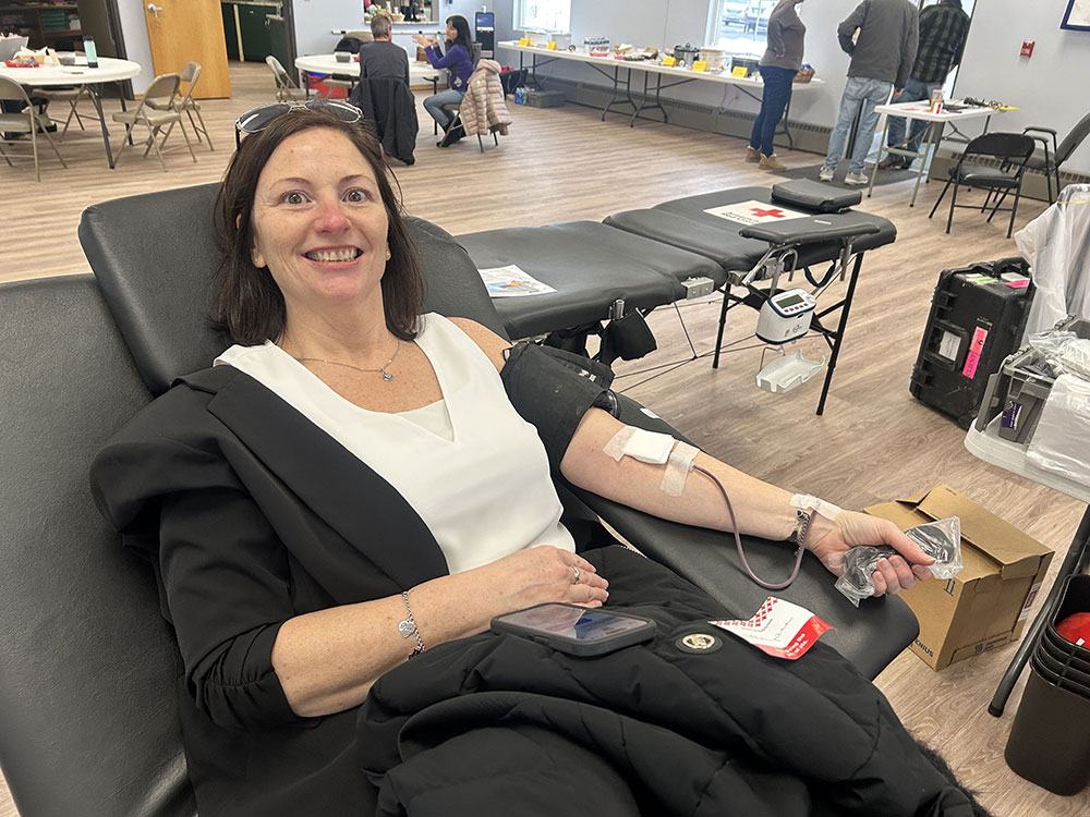 Maryann Manzi sitting in a chair and donating blood.