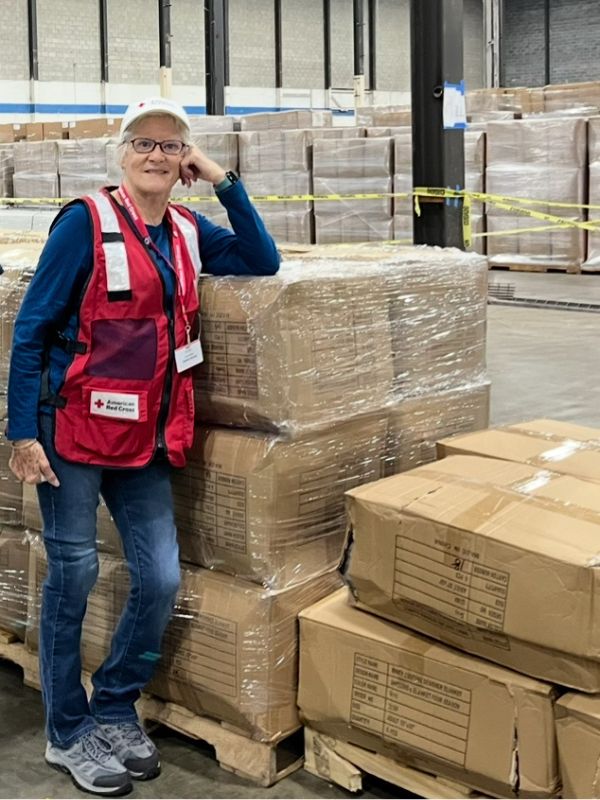 volunteer ruth standing near boxes in warehouse
