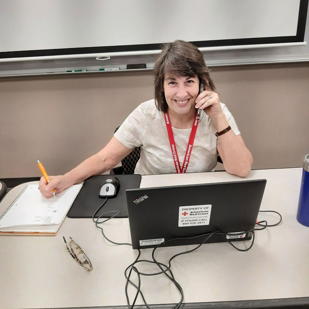 Stephanie Carter sitting at a desk with a laptop and pad of paper.