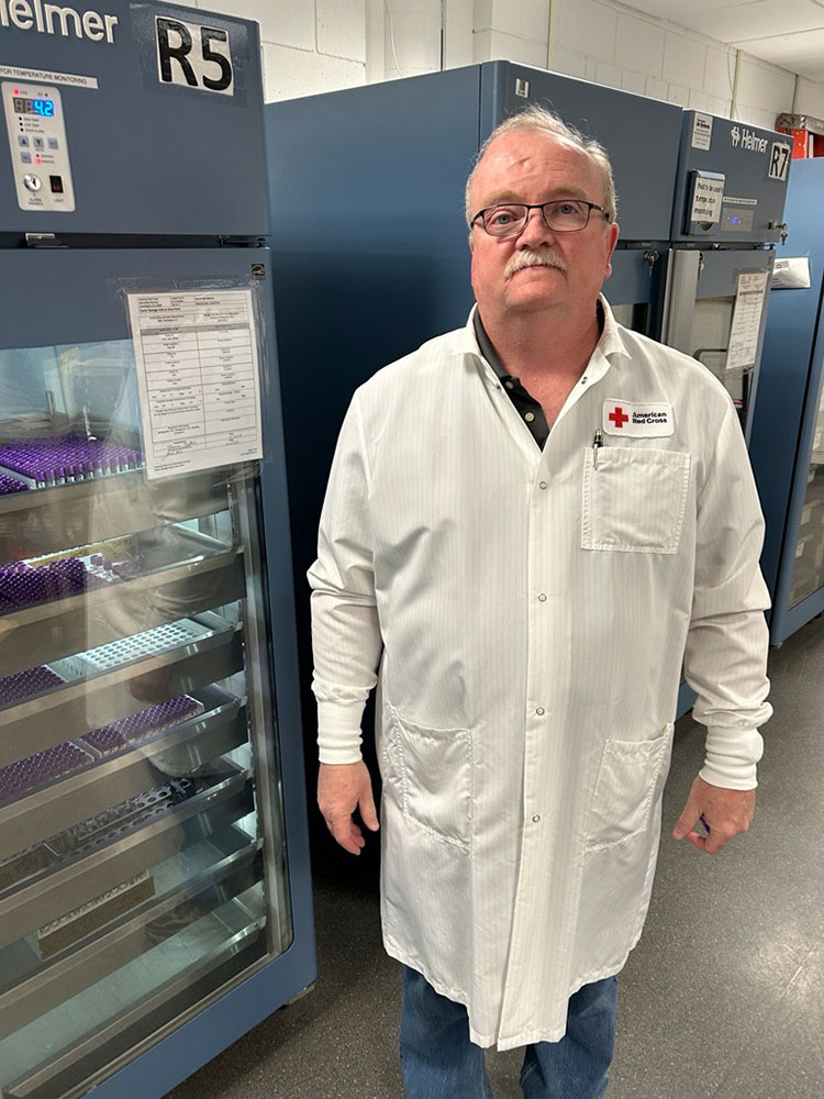 Tom Nattress in a lab wearing a red cross lab coat.