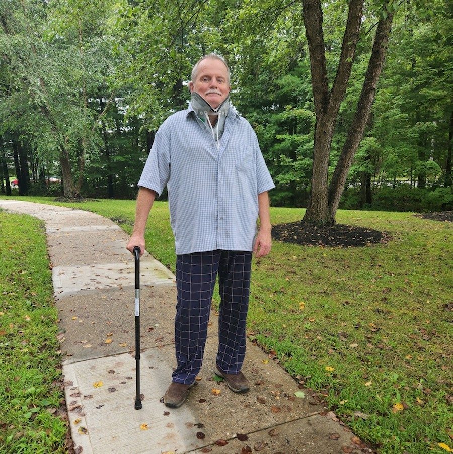 Mainer Mark Munson in a neck brace and walking with a cane after his accident.