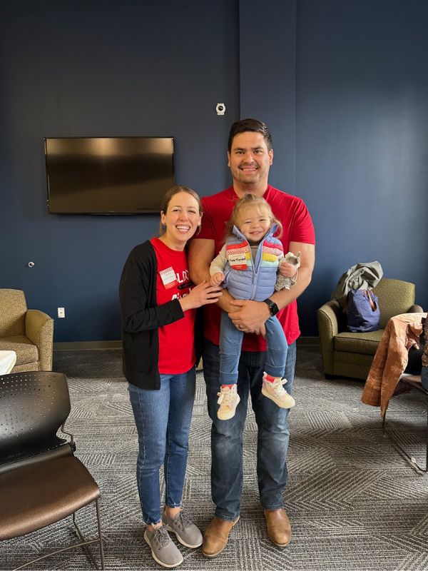 woman who recently donated blood smiling with man holding young child