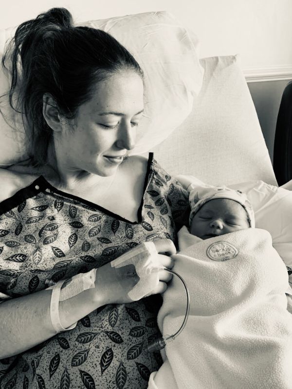 woman holding newborn baby in hospital bed