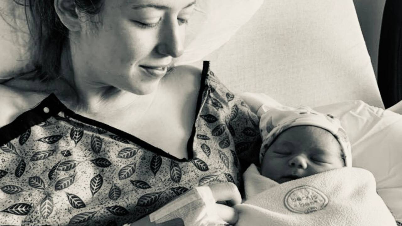 woman holding newborn baby in hospital bed
