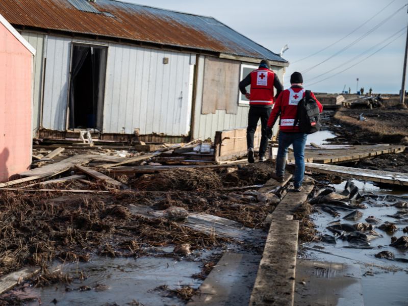 volunteers walking through damaged area.