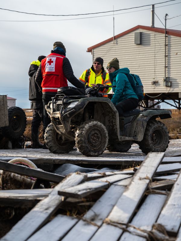 volunteers on atv while assessing the damage.