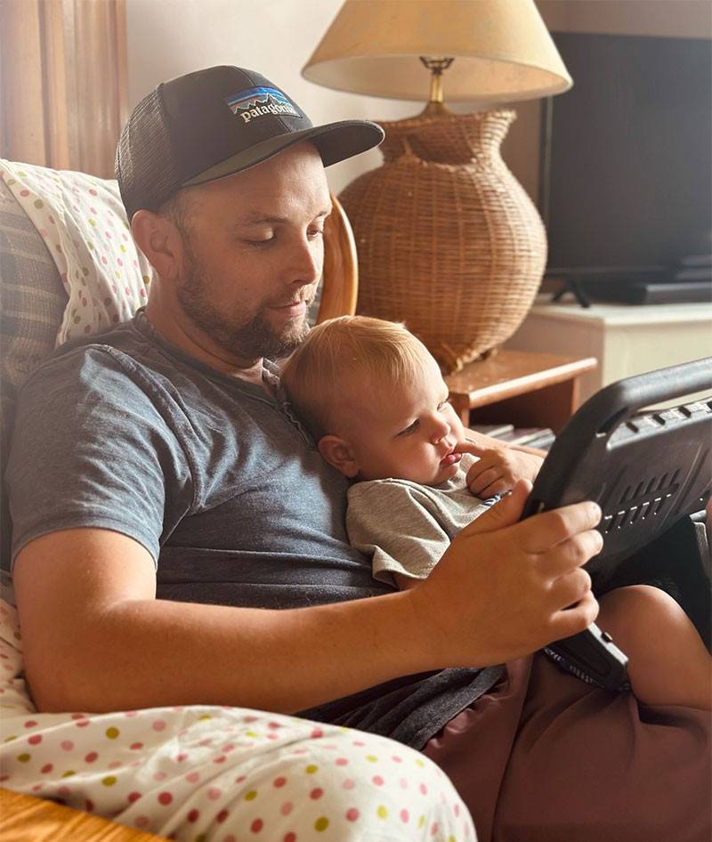 Alex Adams with son looking at tablet