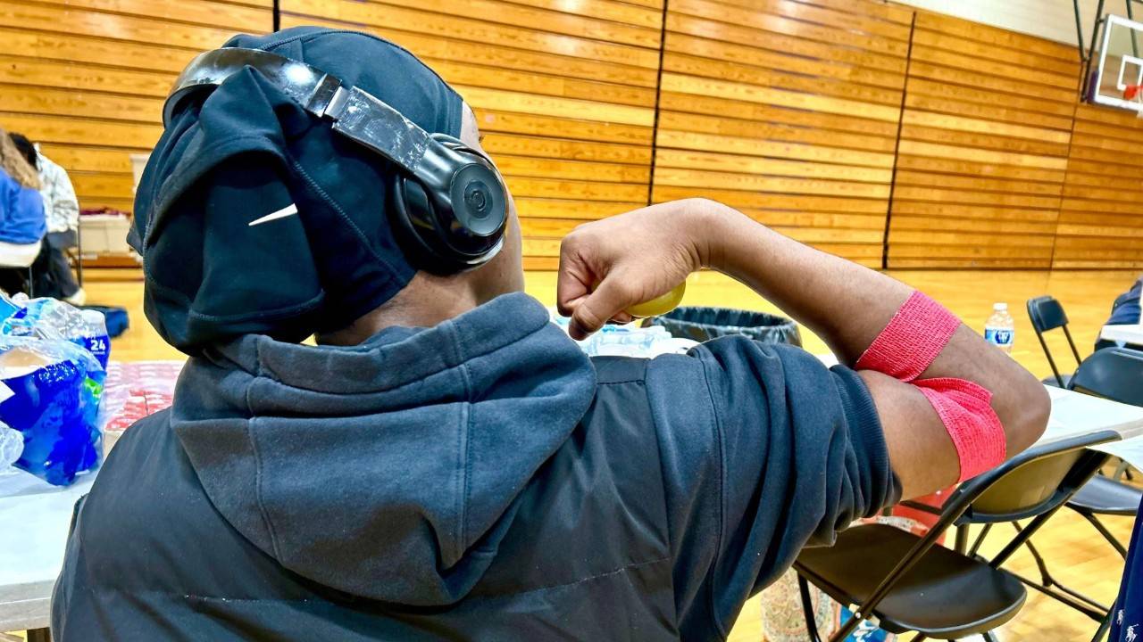 black blood donor rolling up sleeve