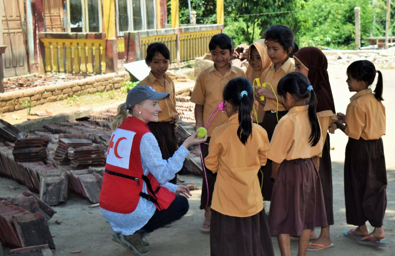 group of happy children pouring water hose in bucket
