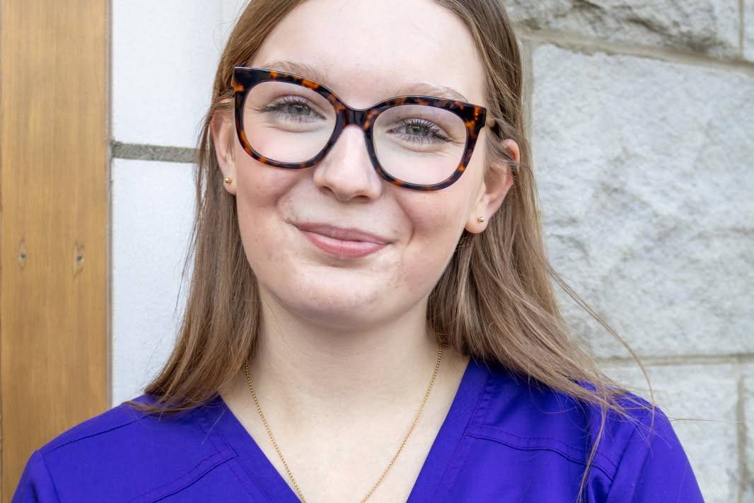 Woman wearing glasses and purple scrubs
