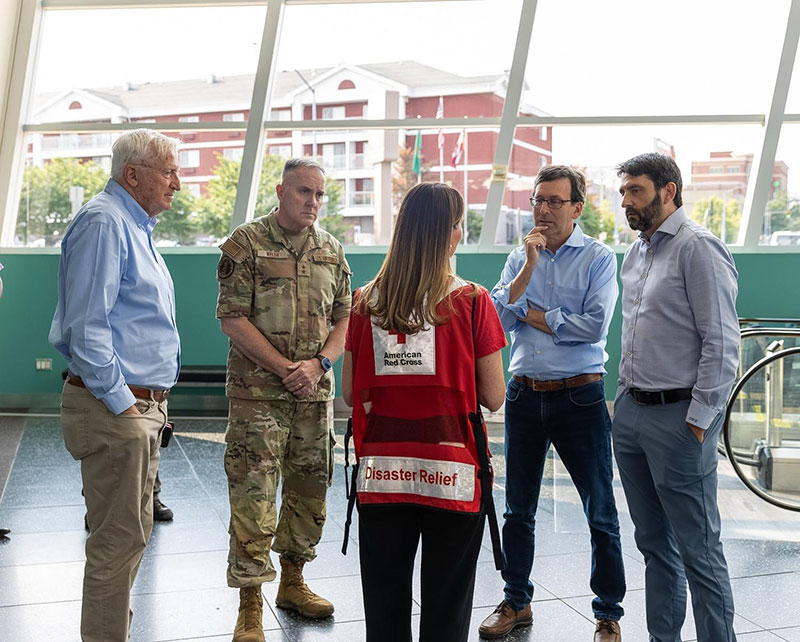 Red Cross staff member speaking with Governor Ferguson and 3 other people.