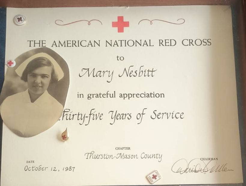 A Red Cross certificate and cut out photo of a woman, thanking Mary Nesbitt for her years of service.