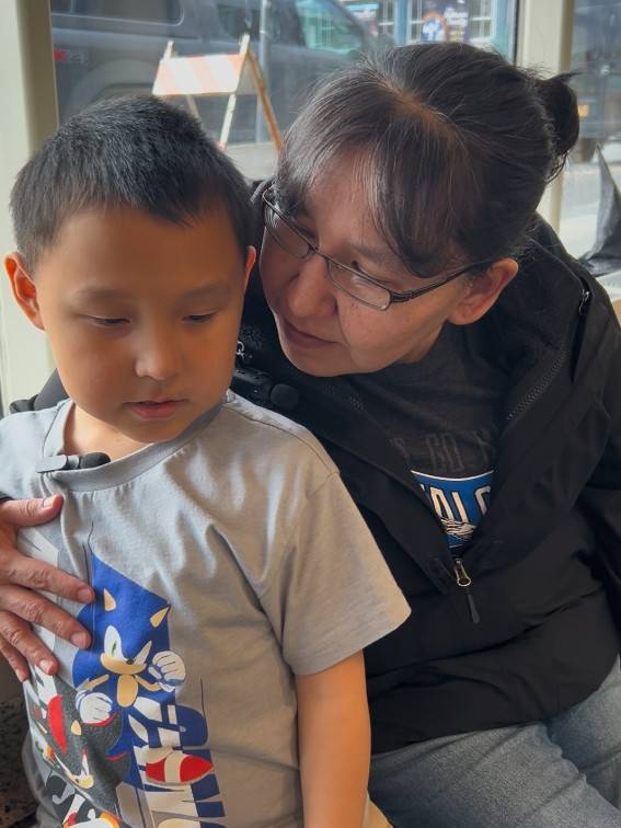 A 6 year old boy and his aunt embrace at a shelter