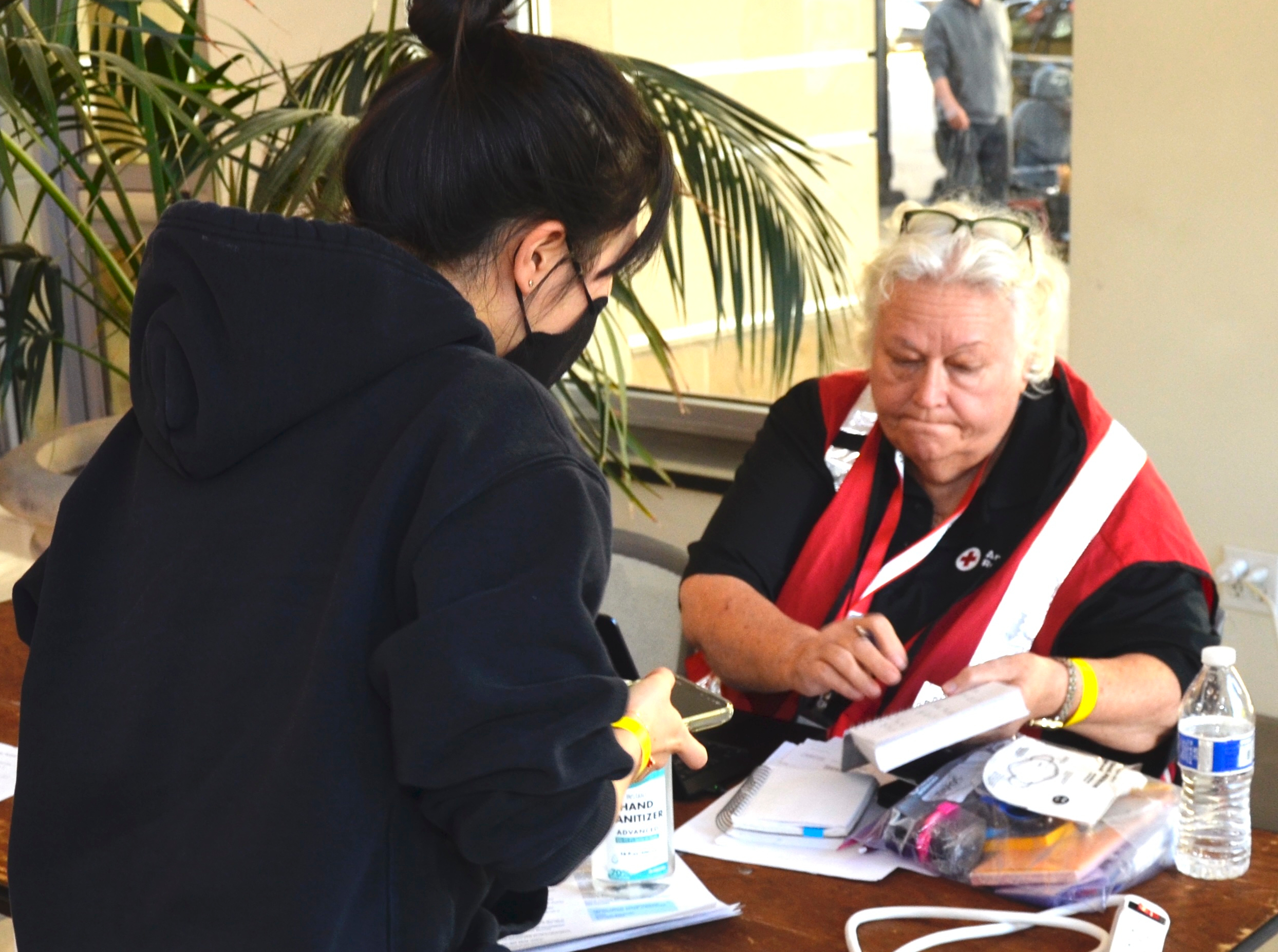Red Cross reunification volunteer sitting at a desk helping a person.