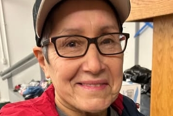 Millie Baquero wearing a hat, glasses and a Red Cross shirt.