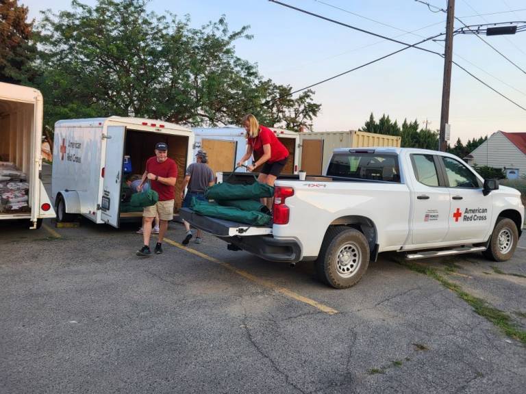  Red Crossers loading up cots, blankets, and comfort kits. They are taking them to the Colville Tribe who opened a shelter in response to the Swawilla fires.