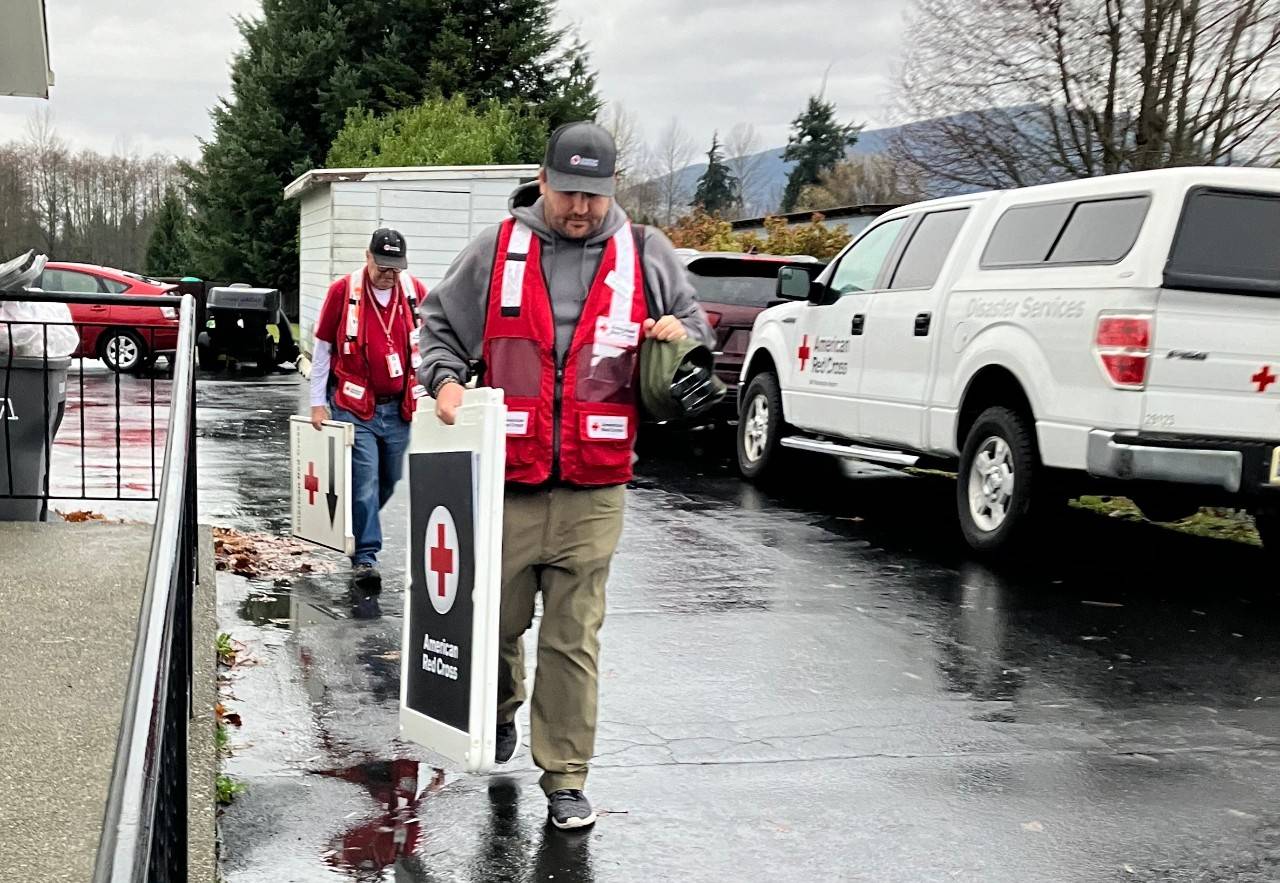 Volunteers carry signs in a parking lot