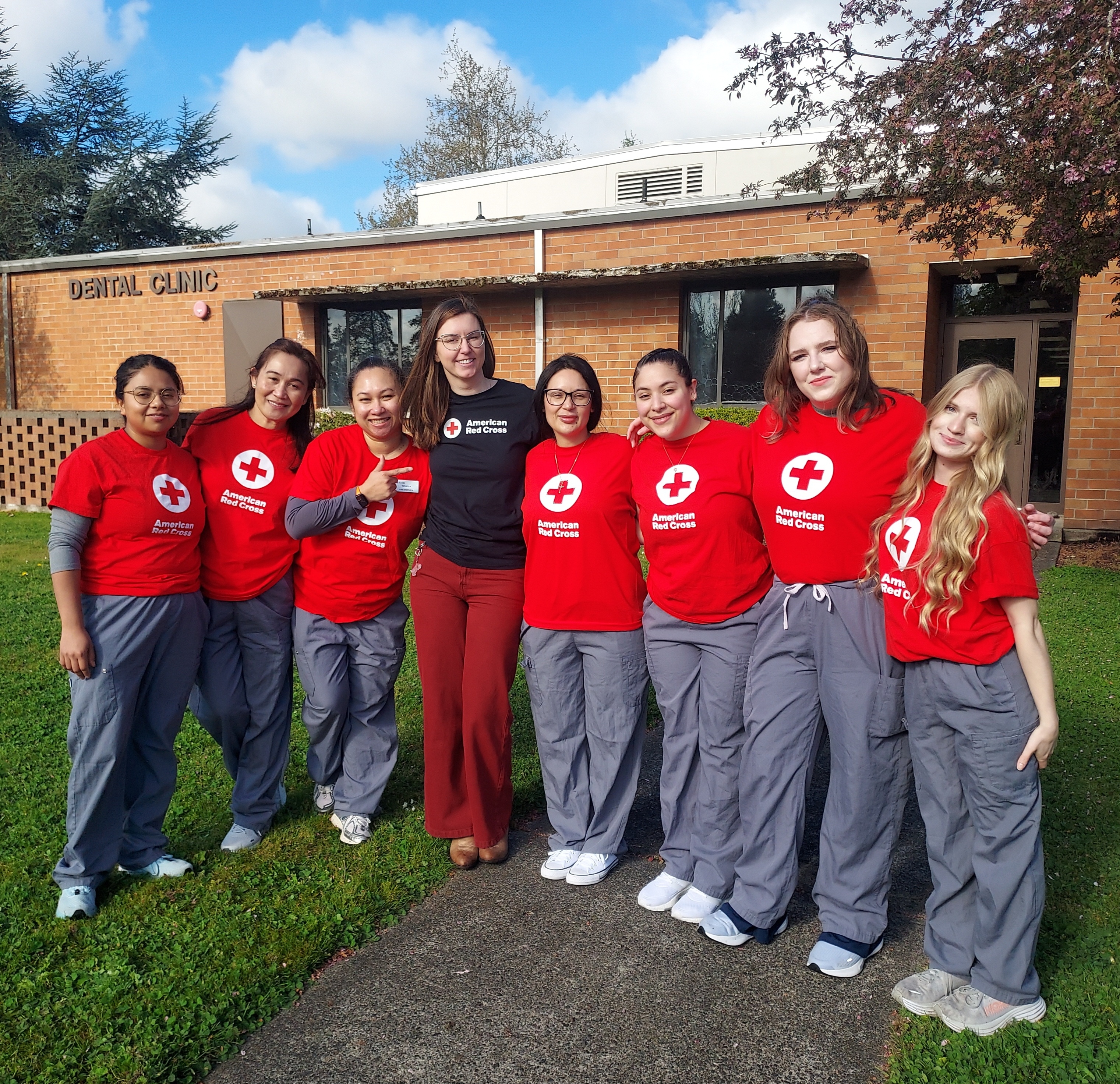 Group of young adults stand in Red Cross tshirts