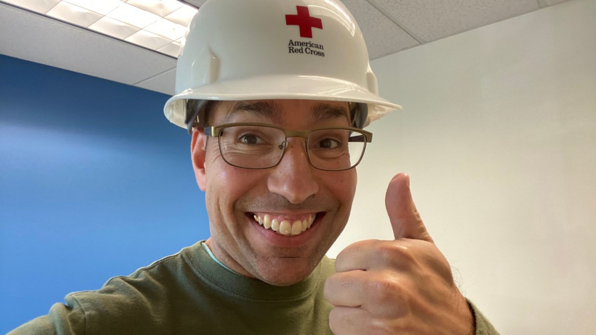 manny martinez holding thumbs up with red cross hard hat on