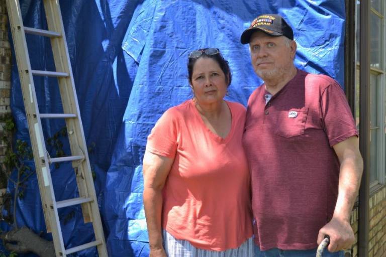 Linda and Scott Hurley stand near their tornado-damaged house in Shawnee, Oklahoma. Linda is grateful that Red Cross disaster workers came to their neighborhood with food and supplies a week after the storm, when they thought their neighborhood had been forgotten.
