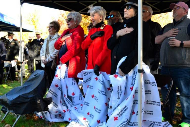 Jimmie McCallum (front row, second from right) and other Pearl Harbor survivor family members recite the Pledge of Allegiance. McCallum’s late husband, Bryan, died in 2008.
