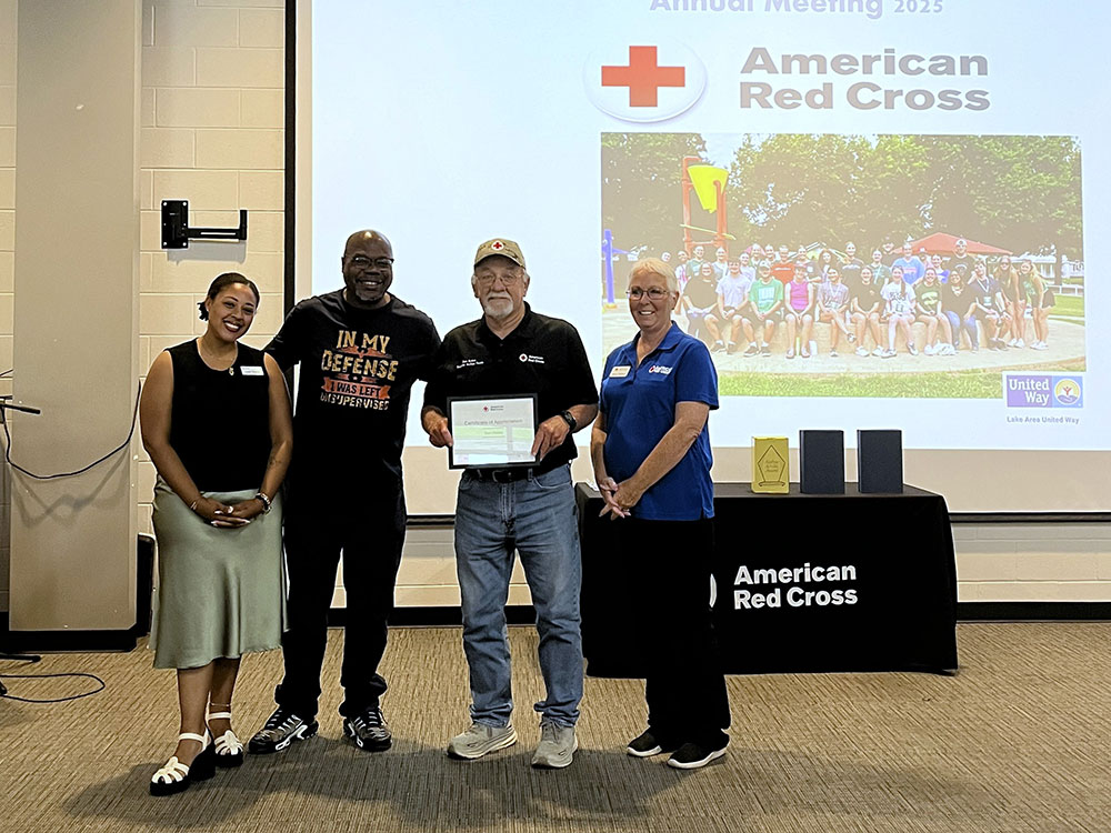 Volunteer Don Dailey holding a certificate of appreciation during the event.
