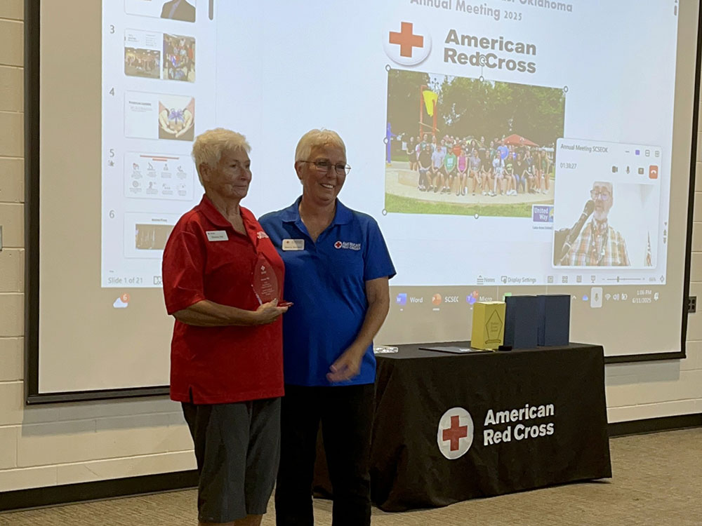 Donna Hill, standing next to Sherry Schauer, holding the Clara Barton Award for Meritorious Volunteer Leadership at an event.