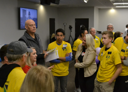 group of volunteers in yellow shirts talking