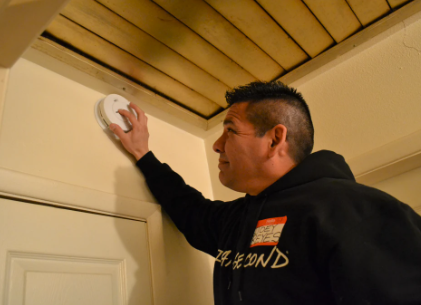 volunteer testing smoke alarm