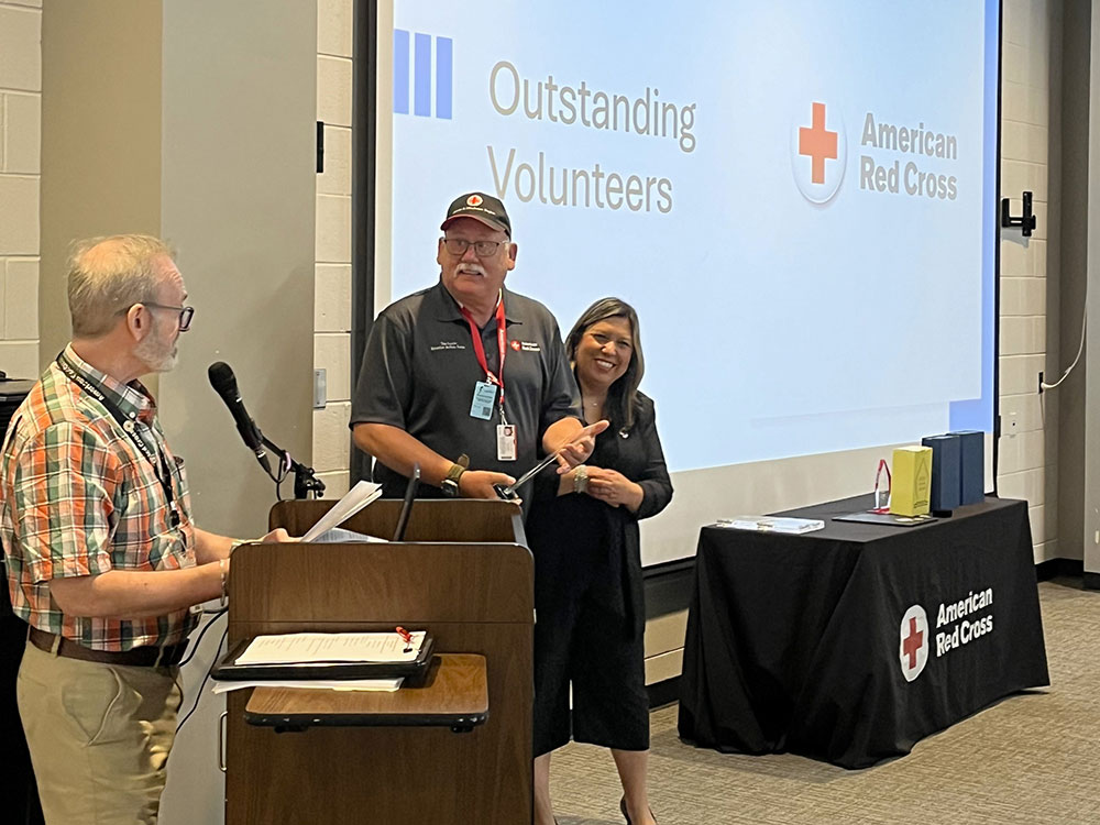 Tim Foote holding the Board of Directors Exceptional Volunteer Award at an event.