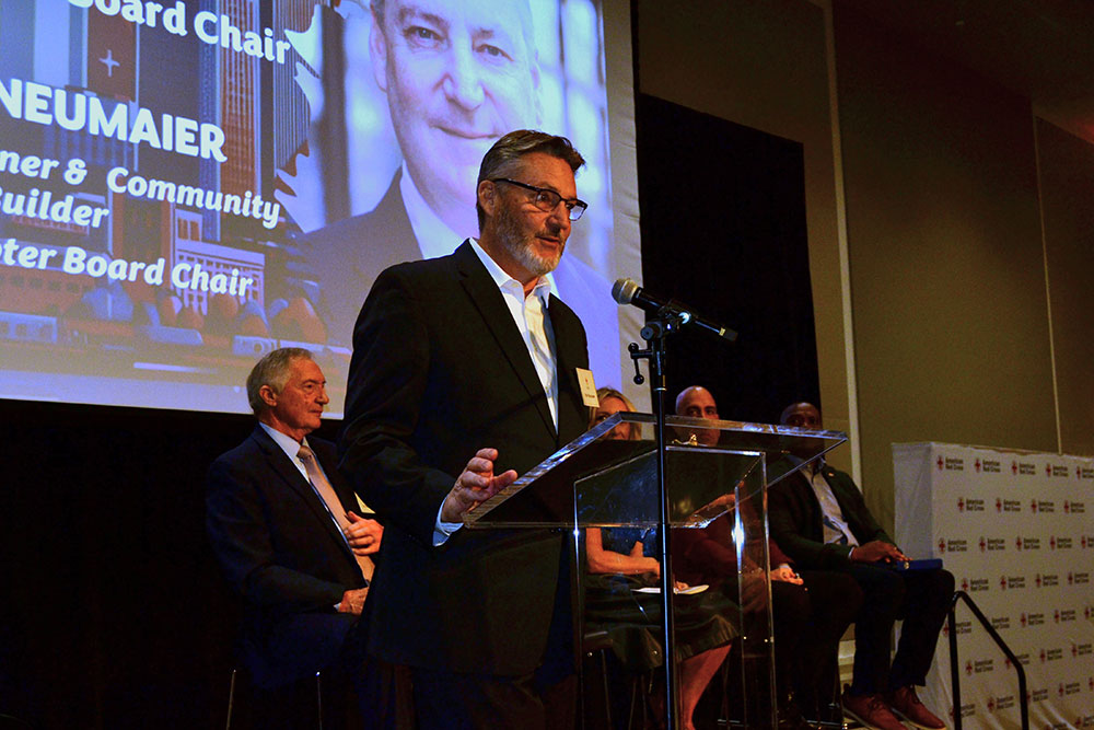 Karl Neumaier speaking at a podium at a chapter event in November 2025.