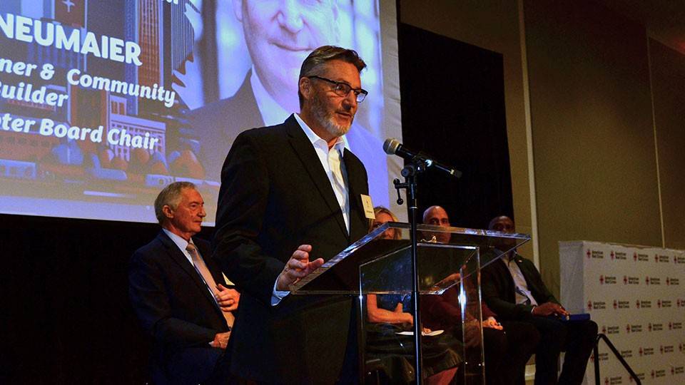 Karl Neumaier speaking at a podium at a chapter event in November 2025.