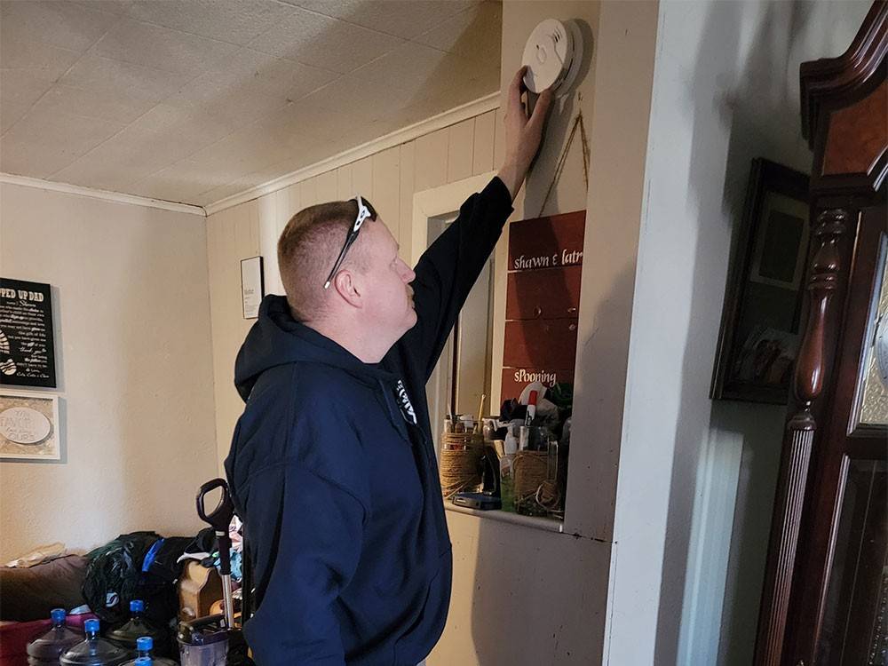 Red Cross volunteer installing a smoke alarm