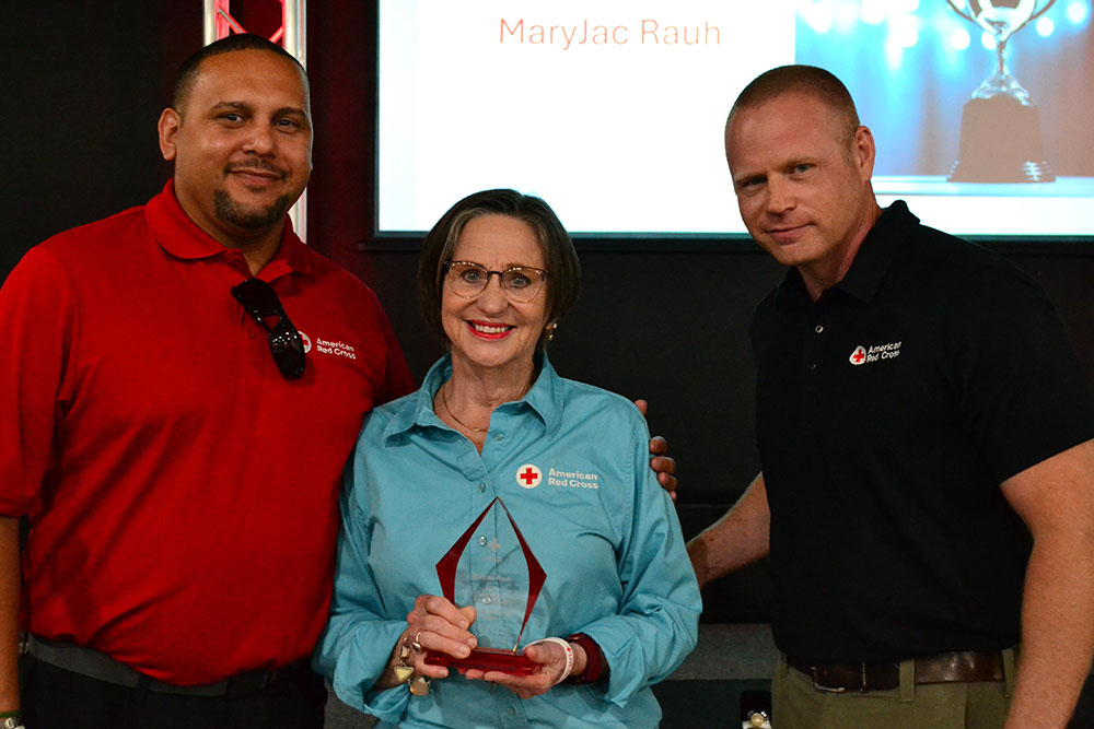 Northern Oklahoma Chapter volunteer MaryJac Rauh holds the 2025 Clara Barton Award for Meritorious Volunteer Leadership with Community Disaster Program Specialist Karvin Vega and Community Disaster Program Manager Stephen Duke standing next to MaryJac..