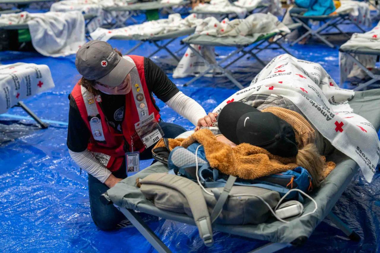 LA Wildfires Volunteer talks to client on cot