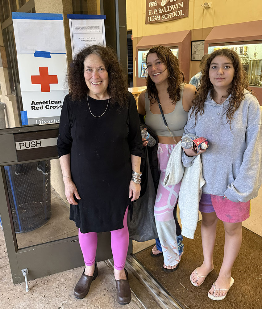 Marilyn Devault and her family pose outside a school building near a Red Cross disaster sign.