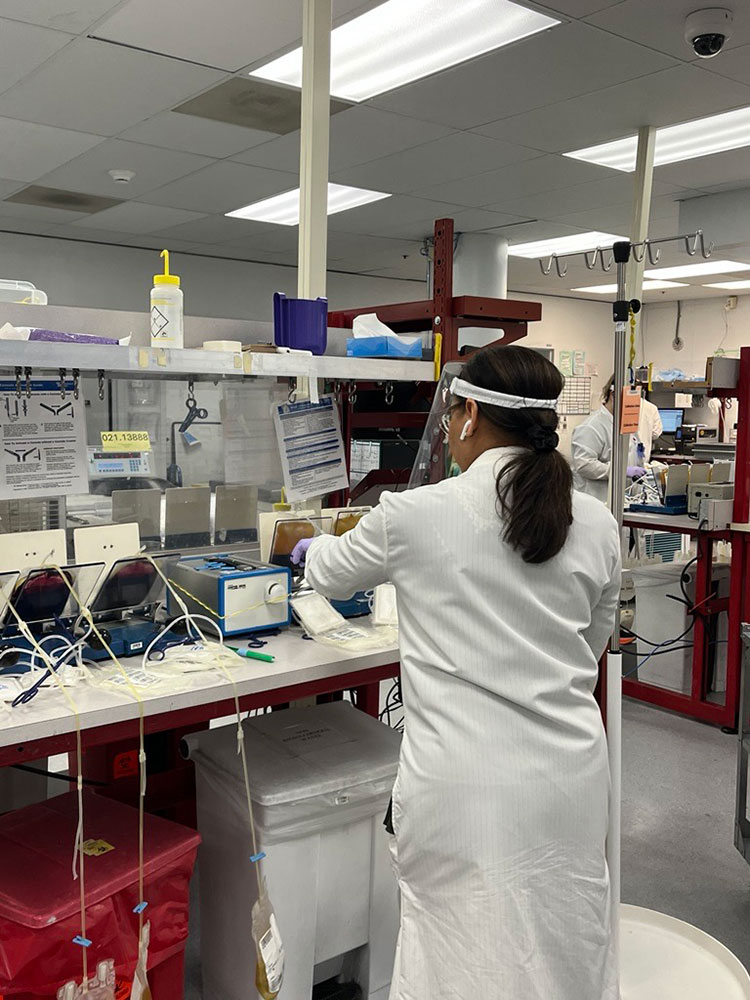 a lab worker wearing a white lab coat working in a lab.