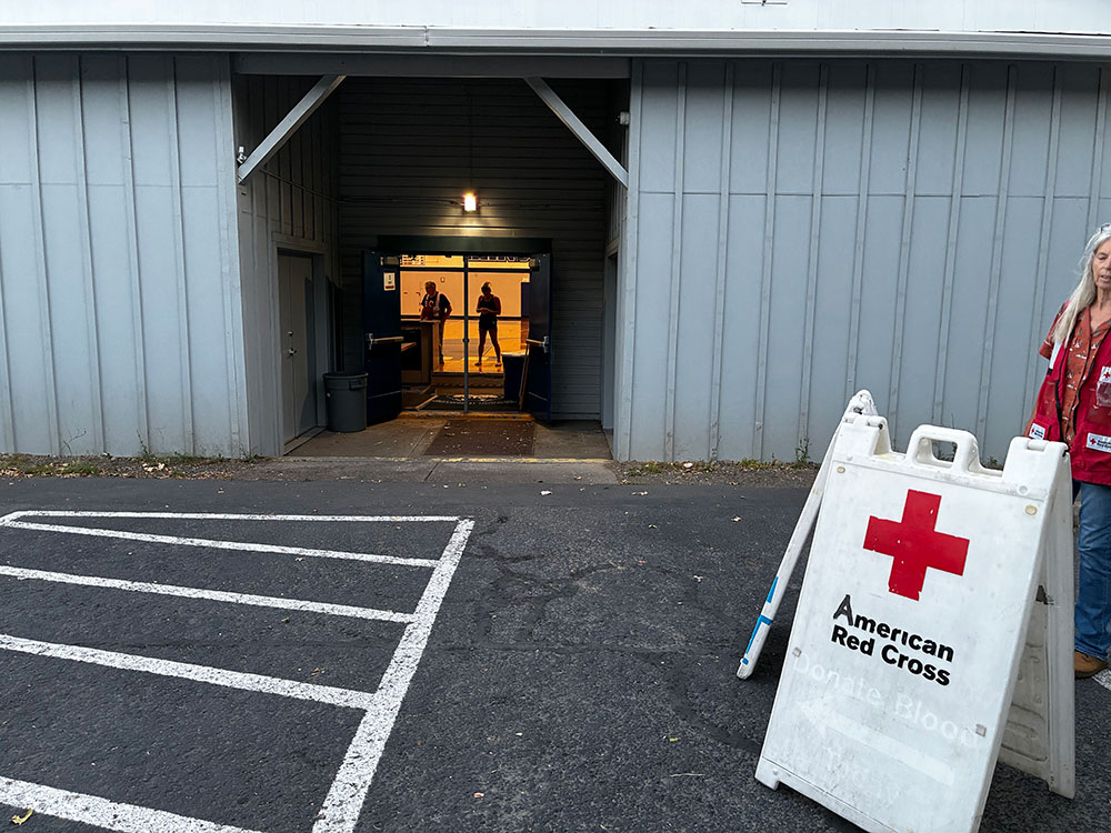 a sandwich board American Red Cross shelter sign at the front of a building.