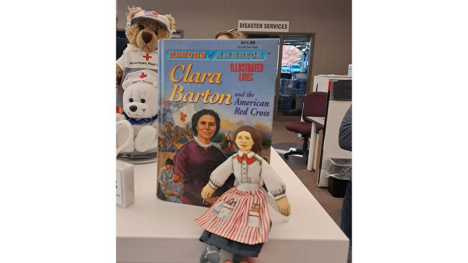 Clara Barton book and doll displayed on a counter top.