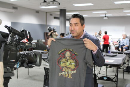 man holding firefighter tejedas t-shirt.