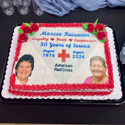 A 50 years of service cake with pictures of a Marcia Raisanen when she started with Red Cross and today.