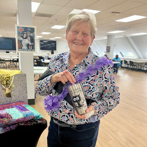 Marcia Raisanen holding a thermal cup and smiling for picture.