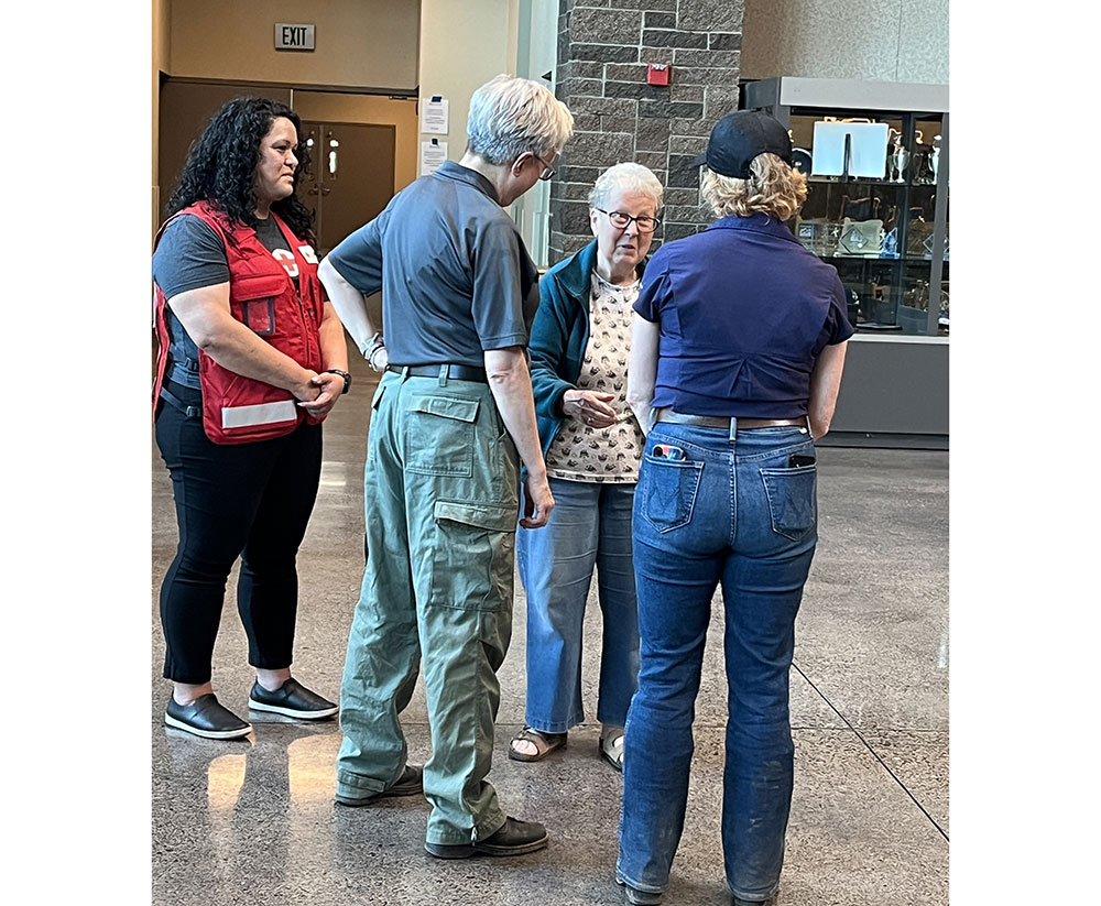 Marylee Dilley speaking to three people in a Red Cross shelter.