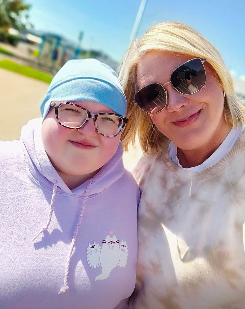 Nicole Ek, wearing sunglasses, and daughter Emmie, wearing beanie and glasses.