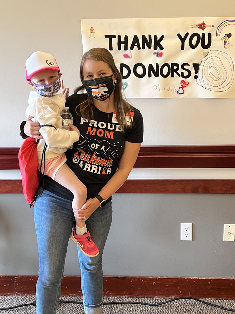 Olivia being held by her mom at a blood drive.