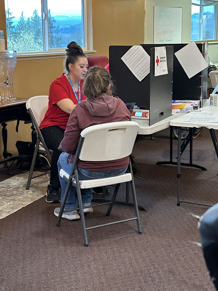 Brianna Buchanan sitting with a donor at the blood donation center.