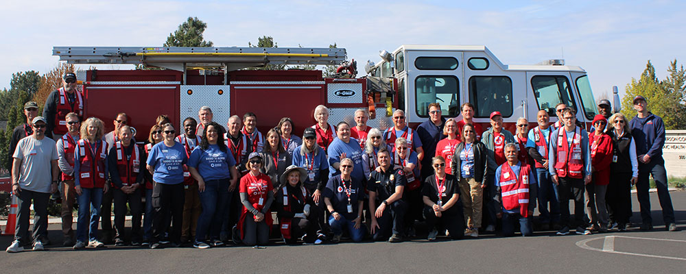 Red Cross volunteers group shot in front of a fire engine.