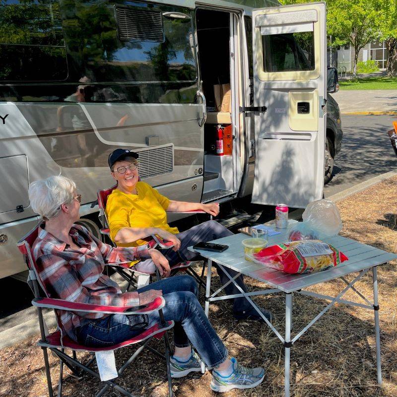 women sitting outside of van