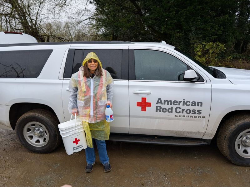 redcrosser standing in front of red cross vehicle with bucket