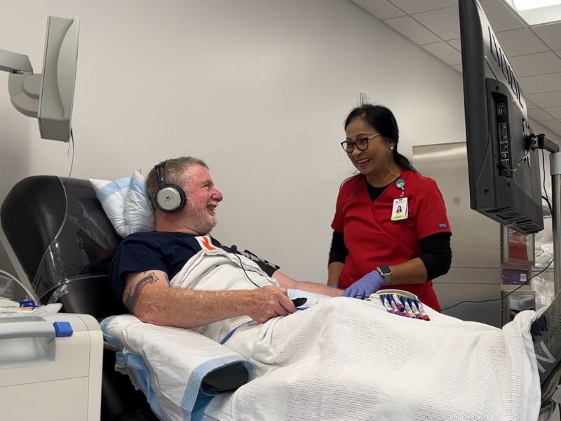 man donating blood smiling at red crosser